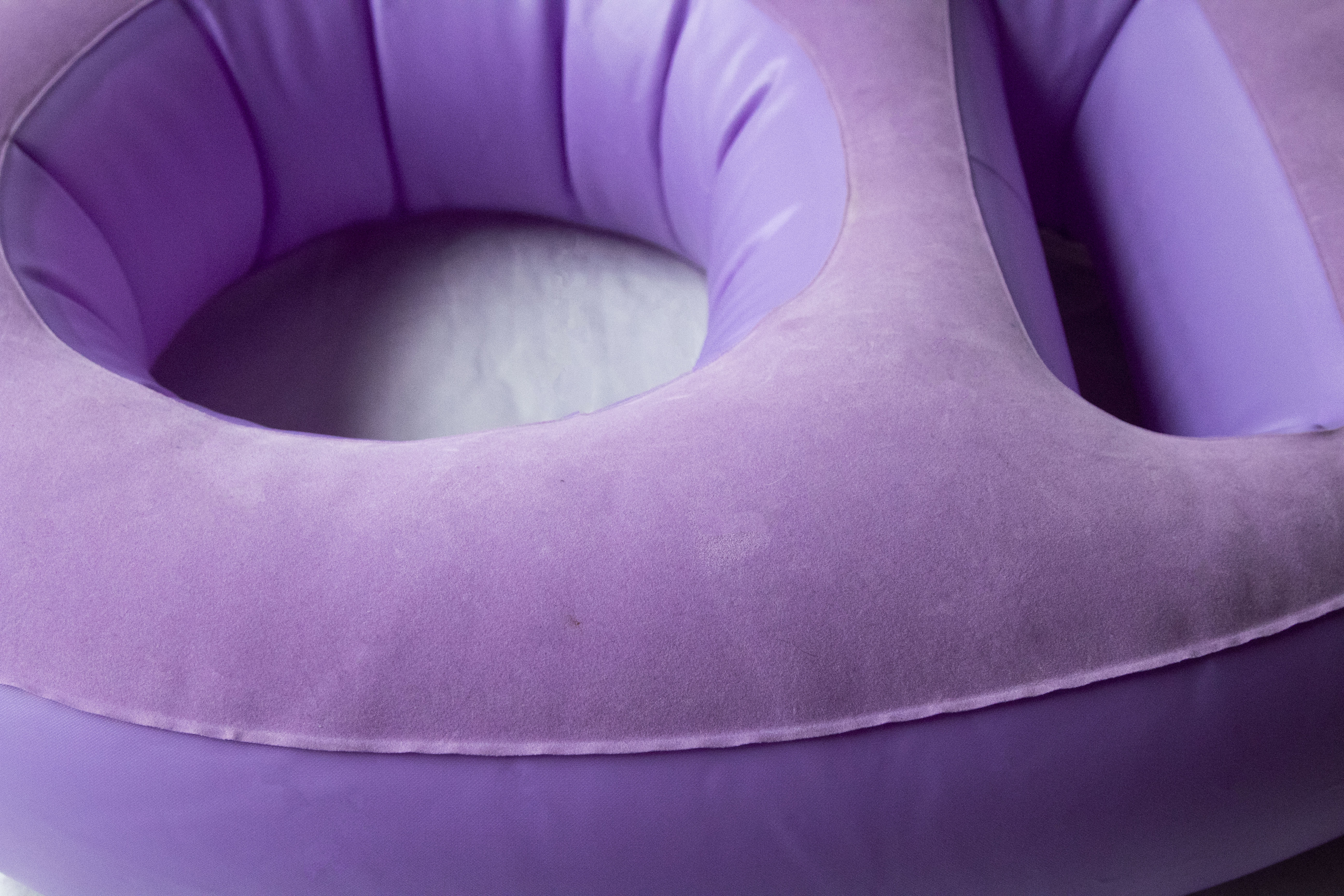 Purple, face-down pregnancy pillow called Tummy Cradle, focus on belly cradle area which is easily inflated or deflated to accommodate any size pregnant belly.