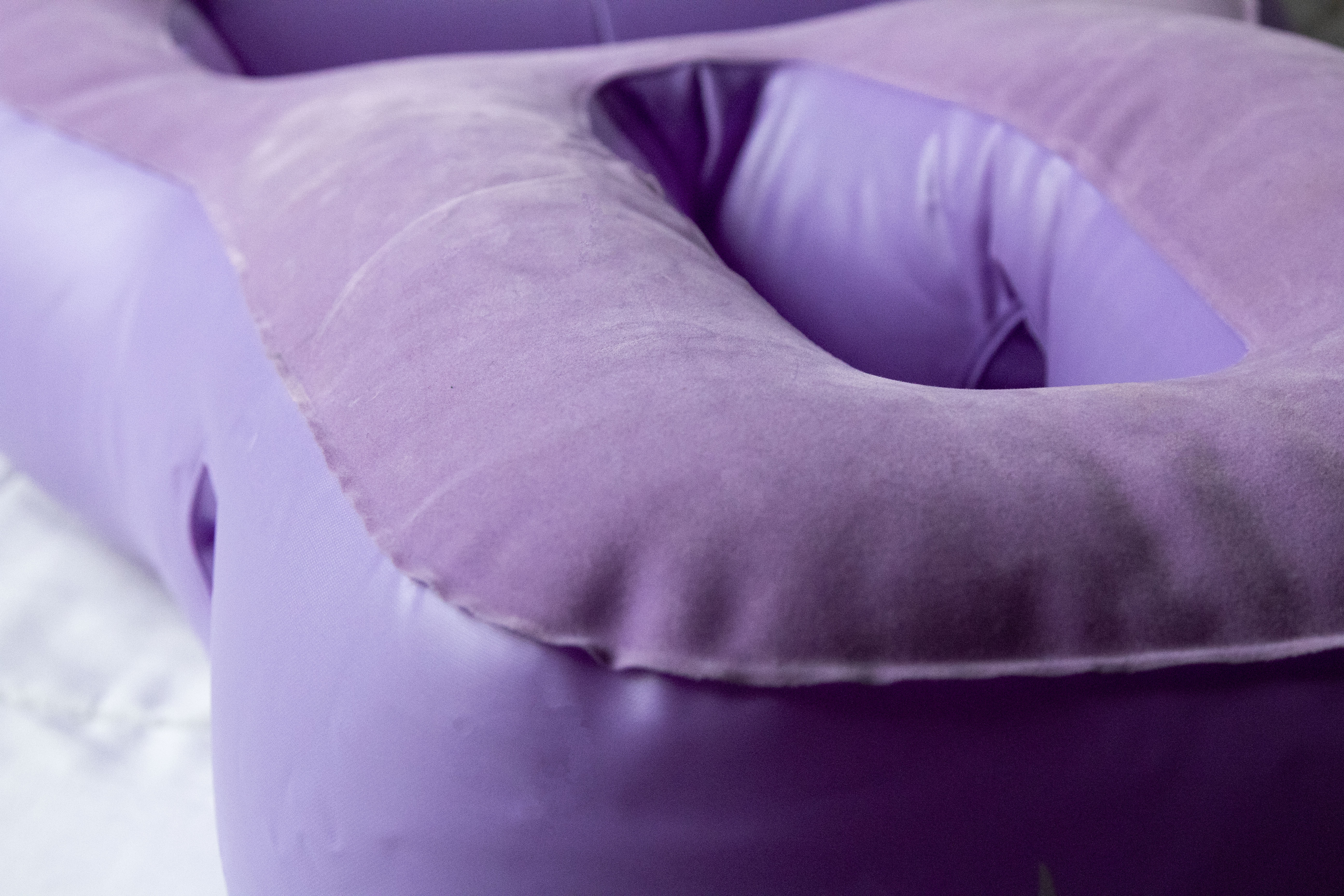 A purple, inflatable pregnancy pillow called Tummy Cradle, with a soft, fuzzy top that feels nice on bare skin.